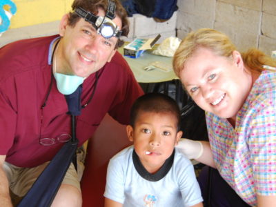 Dr. Daniel W. Ormsby and a mother with her child after their dental check-up