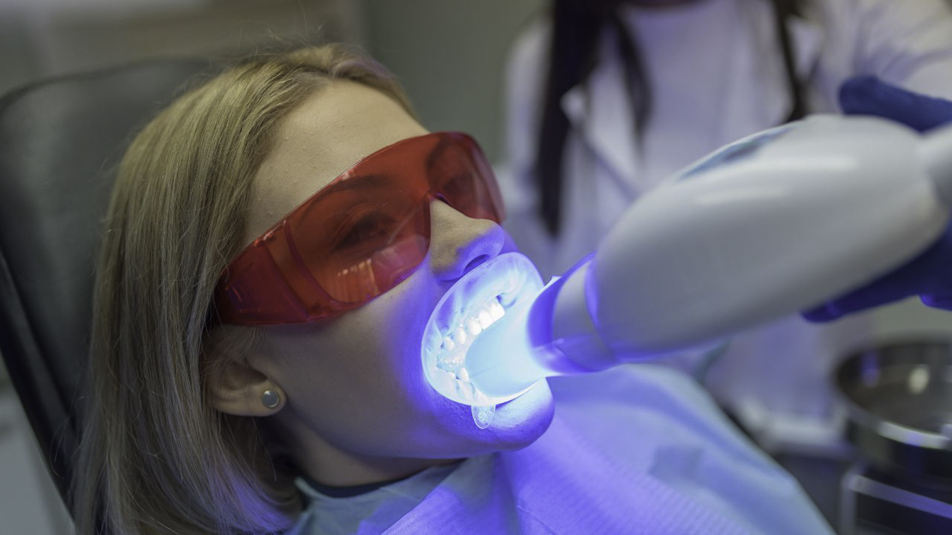 A patient at the dentist having a laser teeth whitening procedure done